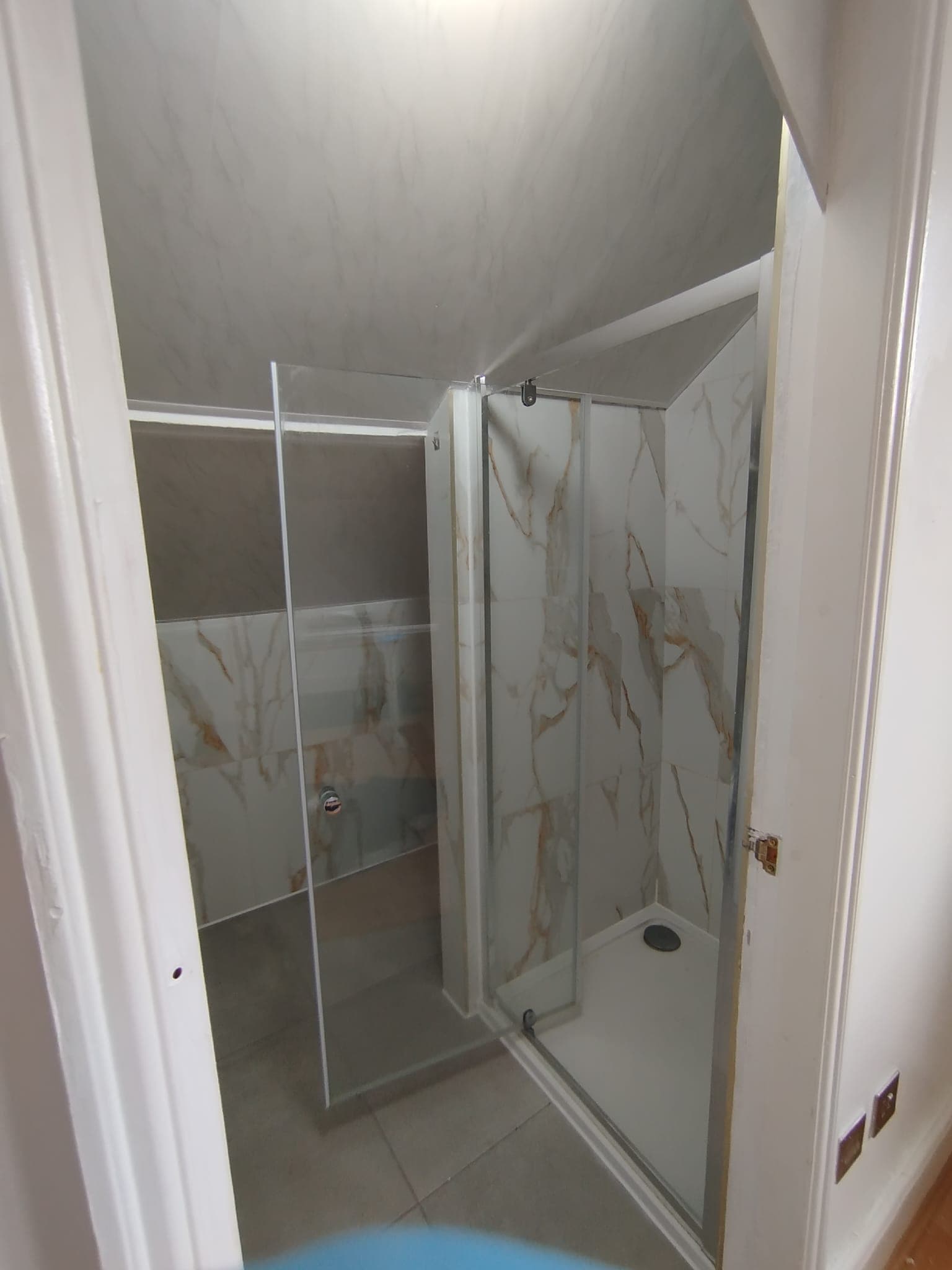 Walk-in shower enclosure with low-profile tray and marble tiling