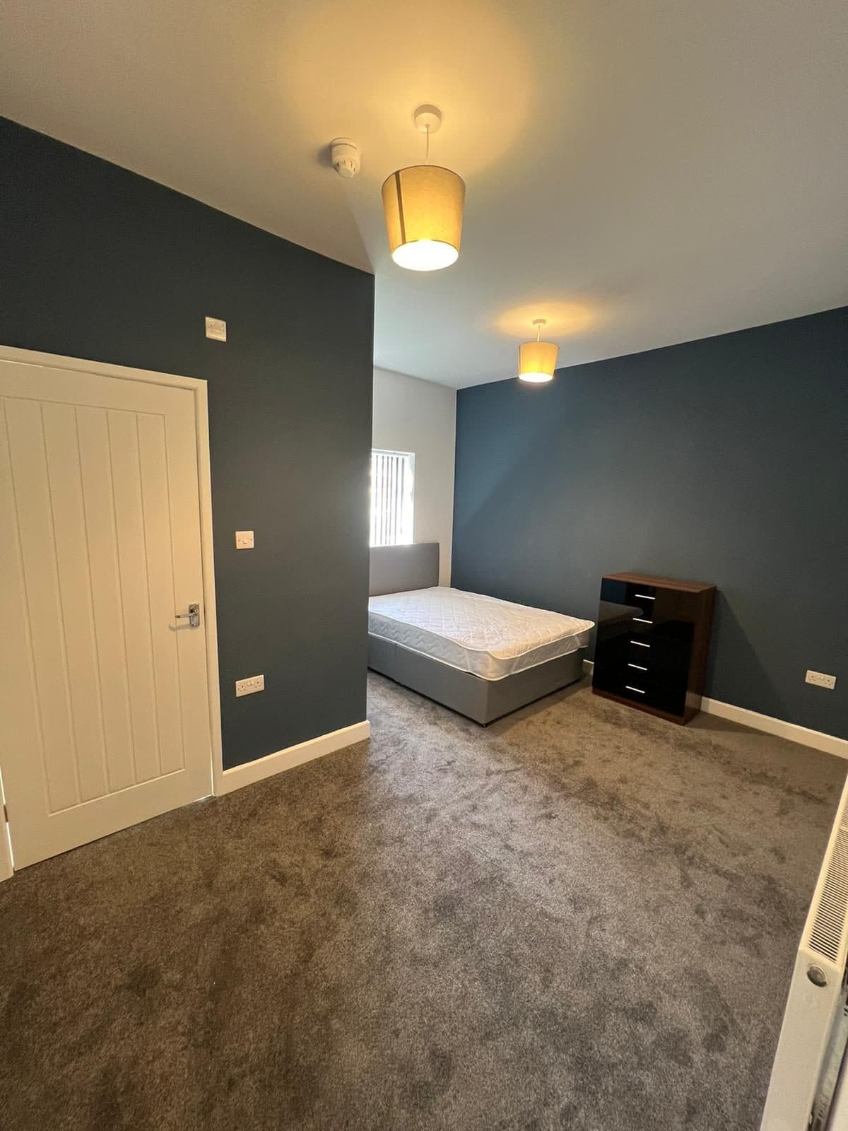Bedroom with navy accent walls and double pendants