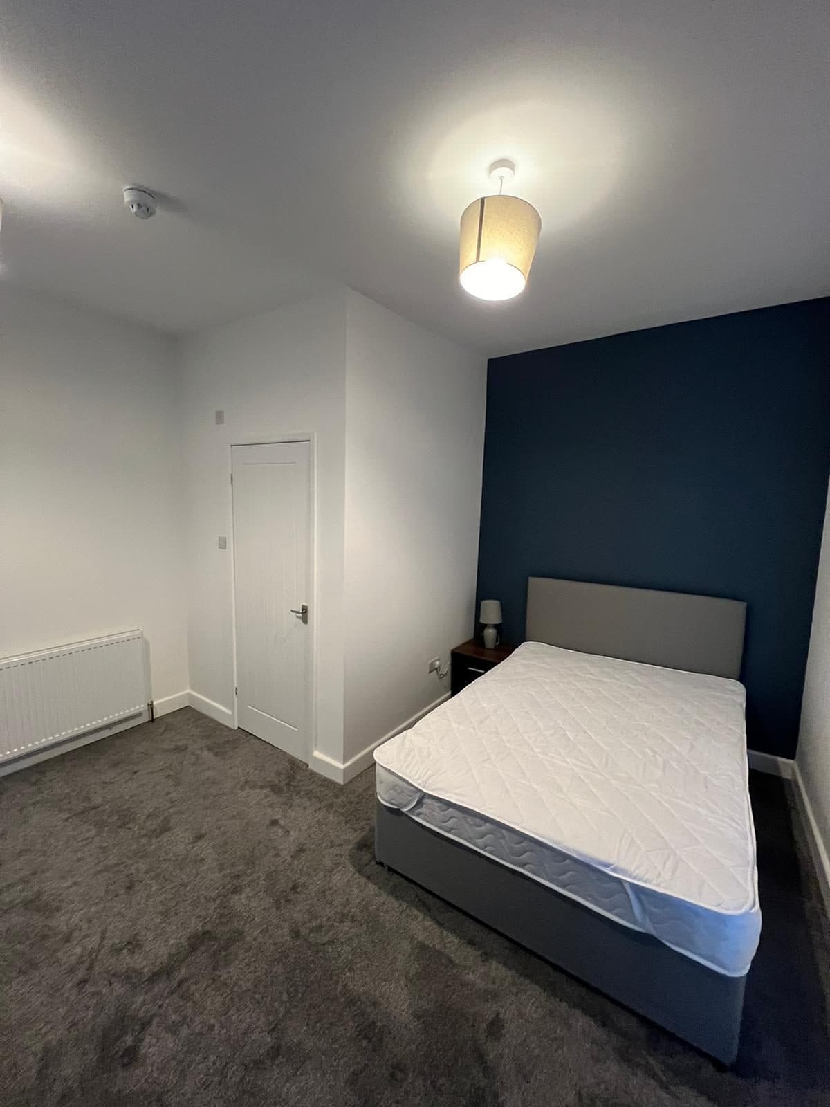 Tenant bedroom with navy accent and bedside lamp