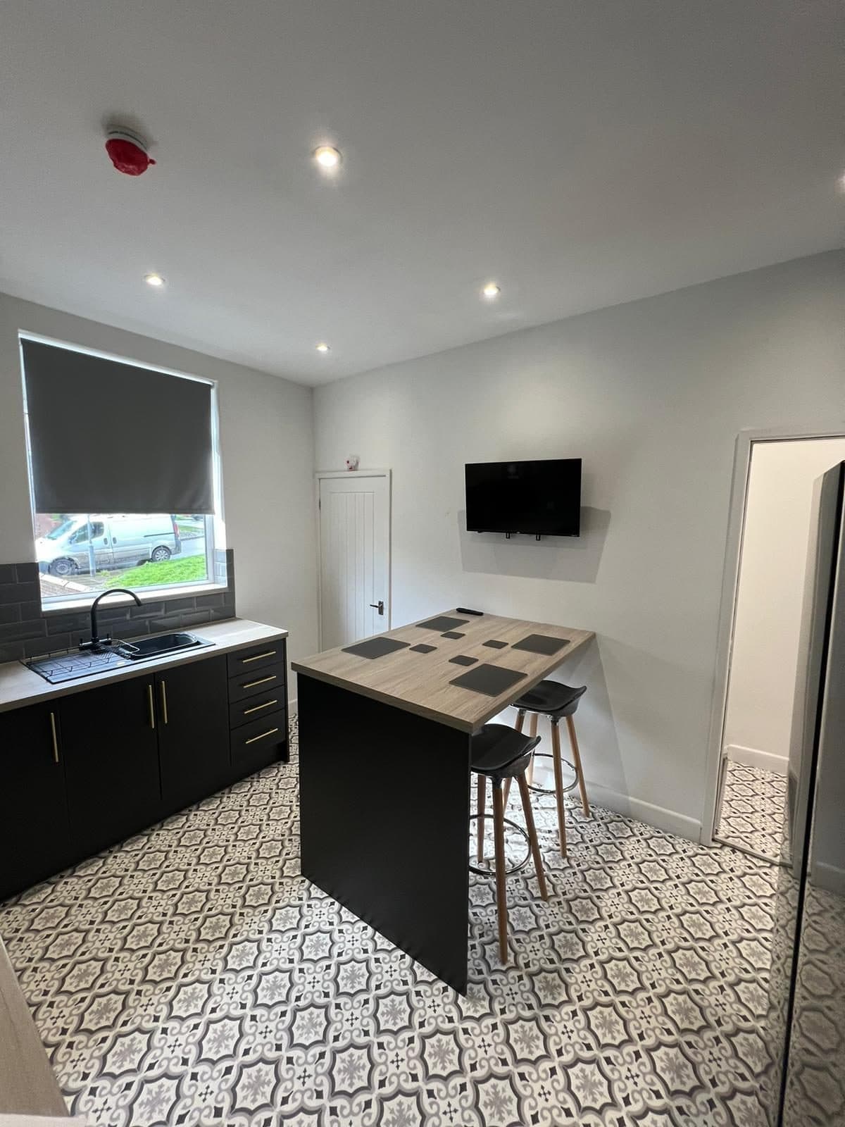Communal kitchen and dining area with wall-mounted TV