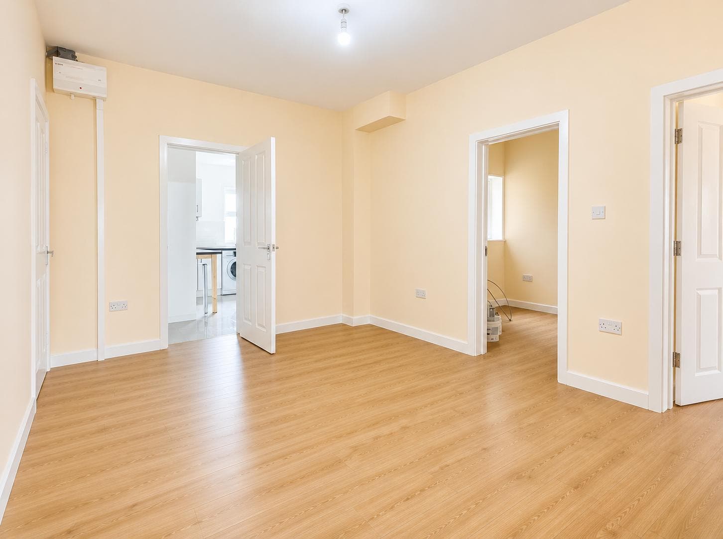 Open lounge area with new laminate flooring leading through to the kitchen and adjoining rooms
