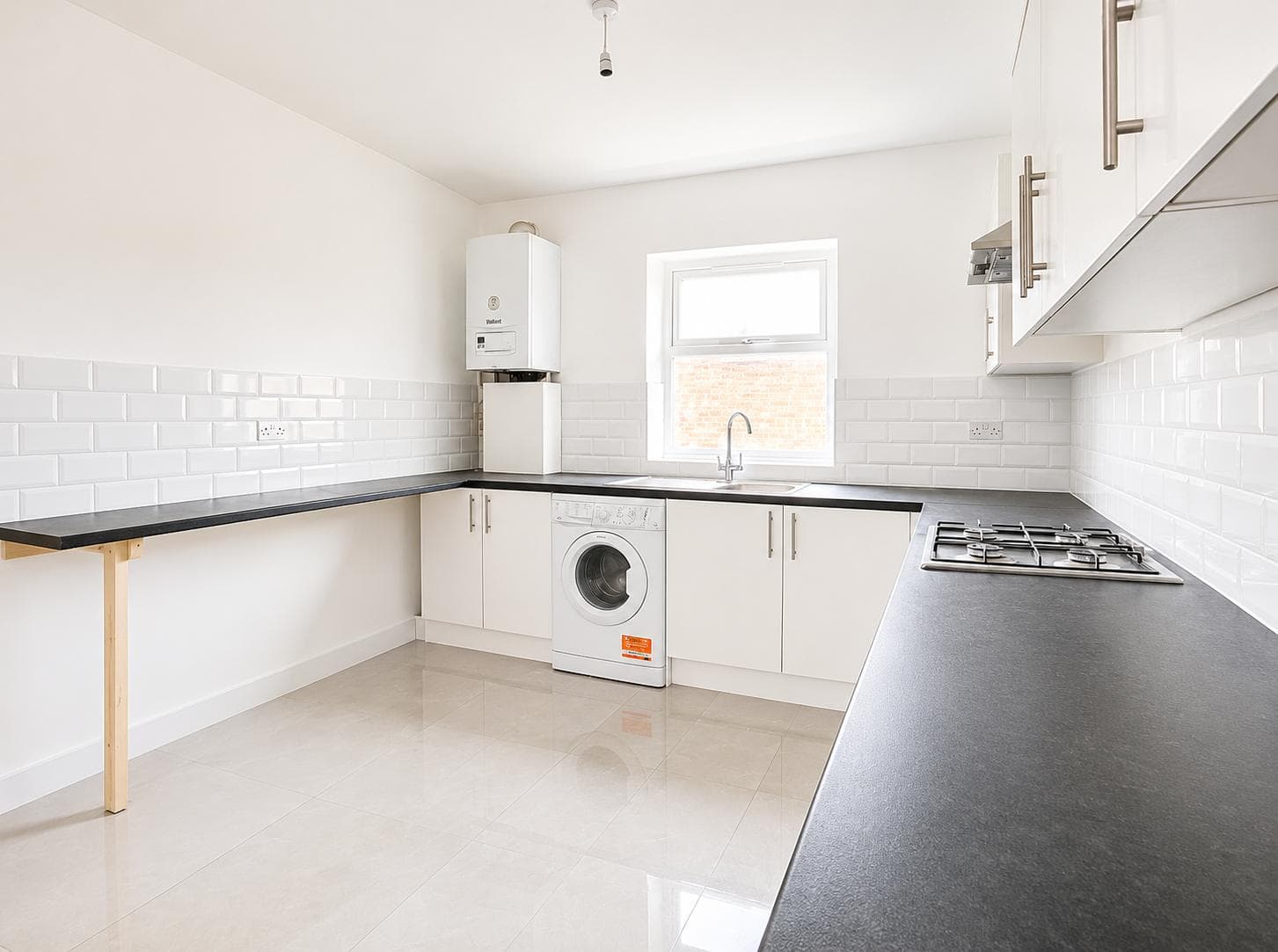 Kitchen with Vaillant boiler, washing machine and dark laminate worktops