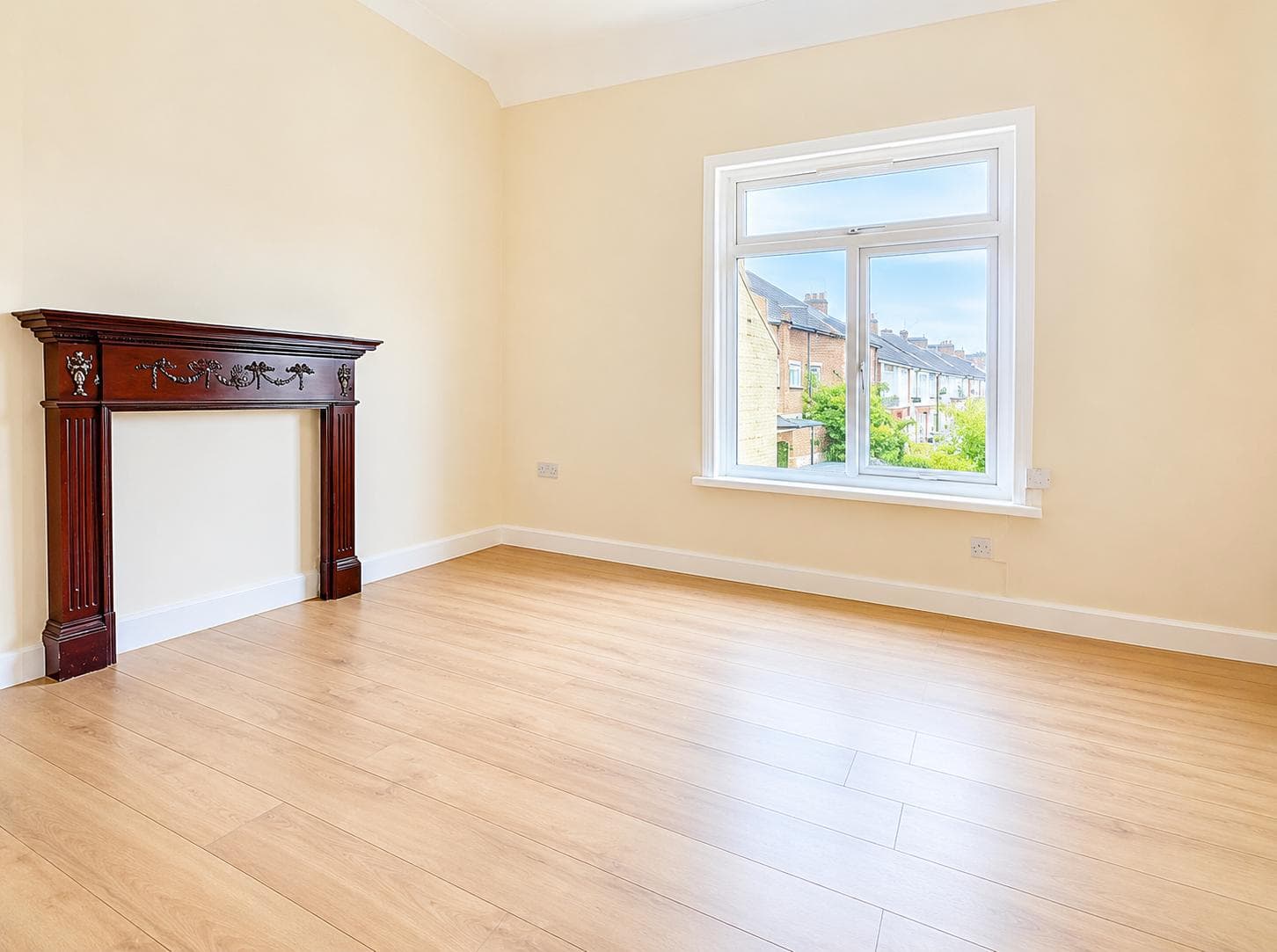 Bedroom with original fireplace surround and bay window over the street
