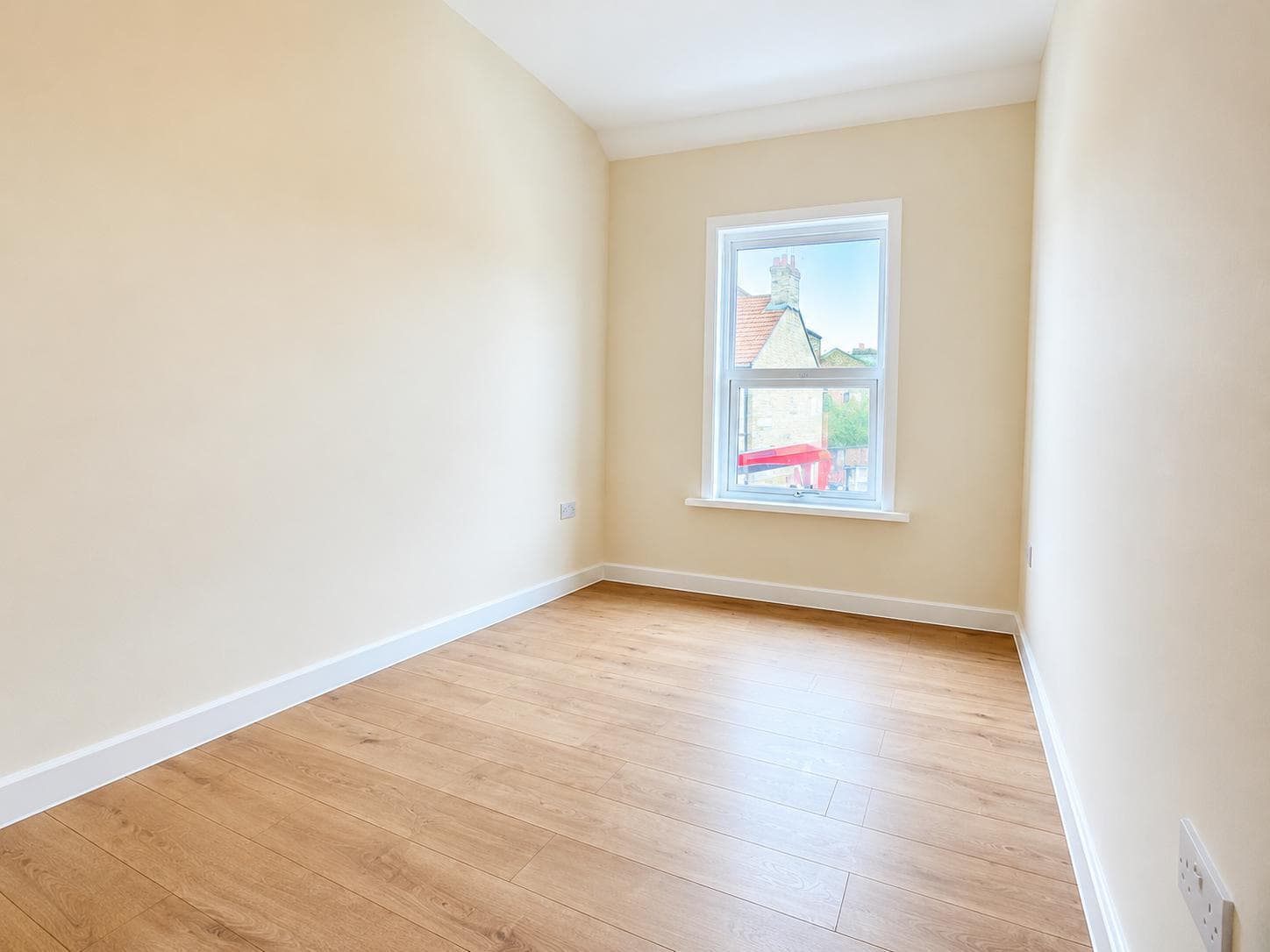 Second bedroom finished in warm neutrals with sash window
