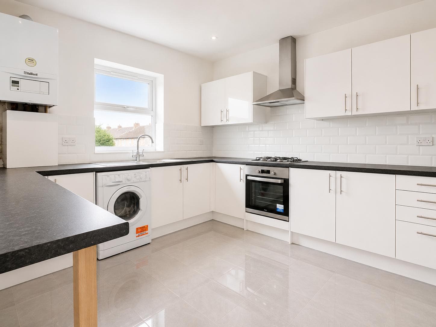 New white kitchen with metro tile splashback, gas hob, extractor hood and integrated oven